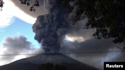 The Chaparrastique volcano, behind electricity cables, spews ash at the municipality of San Miguel December 29, 2013. The Chaparrastique volcano in eastern El Salvador belched a column of hot ash high into the air on Sunday, frightening nearby residents a