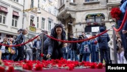 People lay flowers to pay tribute to the victims of a Sunday's blast that took place on Istiklal Avenue in Istanbul