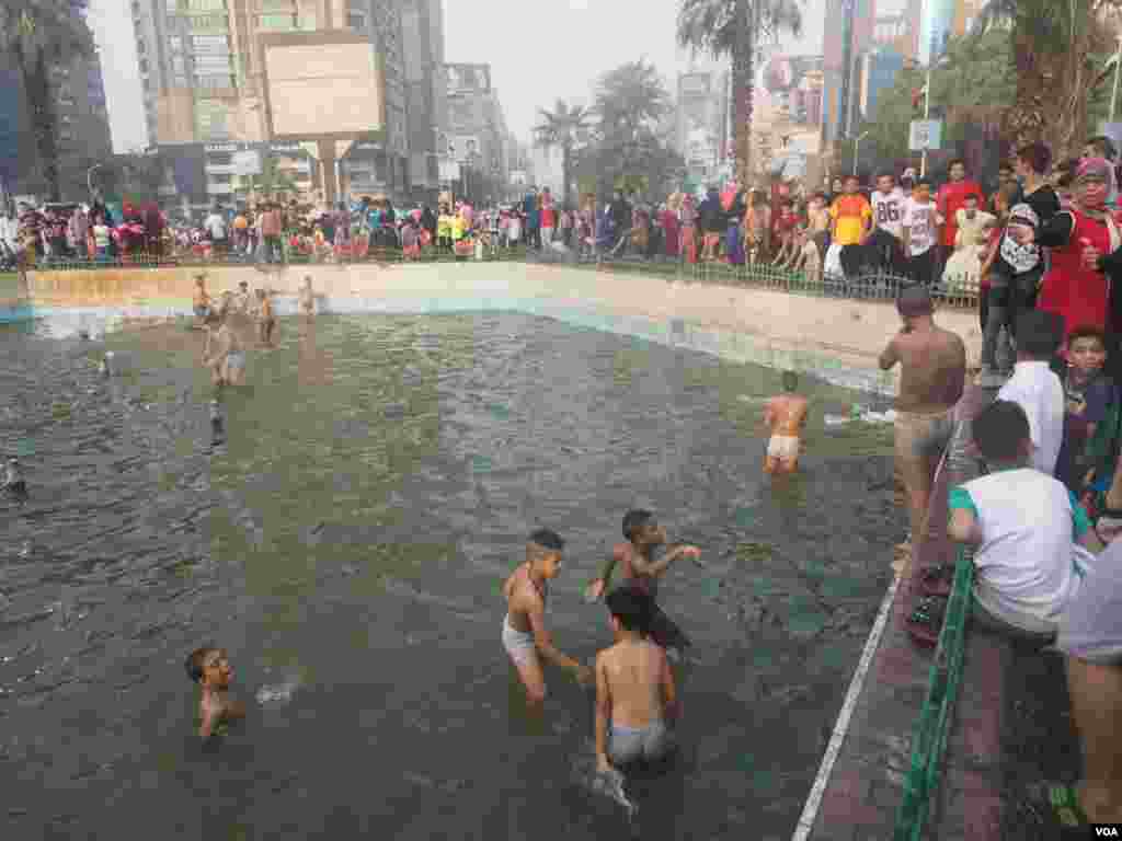 Many children jumped in the public fountain because of the hot weather in Cairo, Egypt. July 6, 2016. (Photo: Hamada Elrasam for VOA)