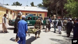 FILE - Afghan men carry an injured man to a hospital after a suicide attack in Faryab province northern of Kabul, Afghanistan, July 22, 2015. 