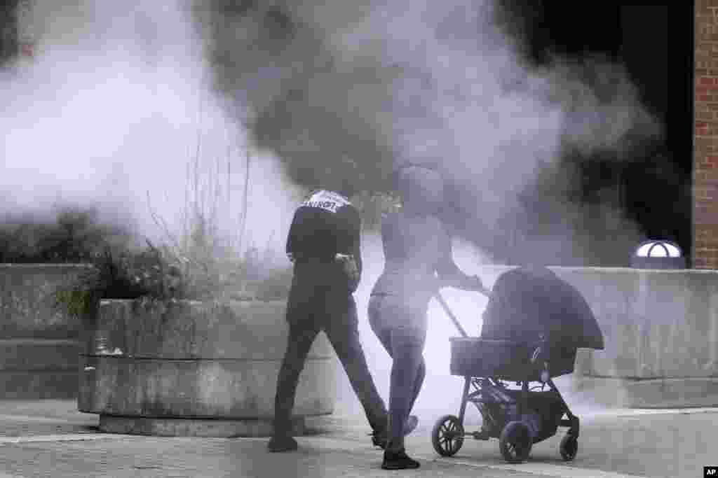 A couple push a baby carriage past steam released in the air as an Arctic blast brings single-digit temperatures with wind chills below zero in Chicago, Illinois.