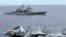 FILE - U.S fighter jets on standby at the upper deck of a USS George Washington aircraft carrier while the USS Cowpens passes by, in the South China Sea, 170 nautical miles from Manila, September 2010.