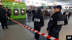 Polisi berjaga dekat lokasi penusukan seorang tentara Perancis di distrik komersial La Defense, di luar kota Paris (25/5). (AP/Remy de la Mauviniere)