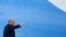 美国总统特朗普7月10日星期五在乘坐空军一号前往佛罗里达州南方司令部前在舷梯上挥手。