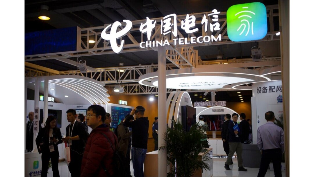 FILE - Visitors look at a display from Chinese telecommunications firm China Telecom at the PT Expo in Beijing, Oct. 31, 2019.