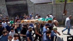 People carry the body of the victim who has been identified as Zelimkhan Khangoshvili, a Georgian Muslim who fought against Russia in the Second Chechen War during the funeral in Duisi village, the Pankisi Gorge valley, in Georgia, Aug. 29, 2019.