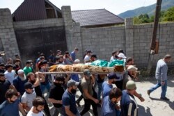 People carry the body of the victim who has been identified as Zelimkhan Khangoshvili, a Georgian Muslim who fought against Russia in the Second Chechen War during the funeral in Duisi village, the Pankisi Gorge valley, in Georgia, Aug. 29, 2019.