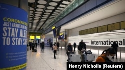 Les voyageurs traversent la zone des arrivées a l'aéroport international Heathrow de Londres, Grande-Bretagne, 18 janvier 2021. REUTERS/Henry Nicholls