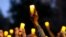 FILE - Marchers hold candles up as they listen to a speaker during a march and candlelight vigil for Ahmaud Arbery in the Satilla Shores neighborhood, in Brunswick, Ga., Feb. 23, 2021.