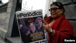 A woman reads a newspaper with a picture of presidential candidate Alejandro Giammattei, the winner of the presidential election, in Guatemala City, Guatemala, Aug. 12, 2019. 