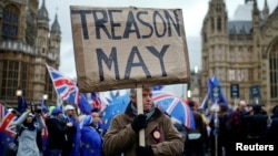 FILE - A pro-Brexit protester holds a banner as anti-Brexit protesters demonstrate outside the Houses of Parliament, ahead of a vote on Prime Minister Theresa May's Brexit deal, in London, Britain, January 15, 2019. 