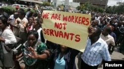 FILE - Zimbabwe's civil servants carry placards as they march during a protest in the streets of the capital Harare, Feb. 19, 2010. 