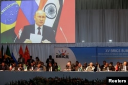 Layar memperlihatkan Presiden Rusia Vladimir Putin menyampaikan pidato secara virtual pada pertemuan KTT BRICS 2023 di Sandton Convention Center di Johannesburg, Afrika Selatan, 24 Agustus 2023. (Foto: via Reuters)