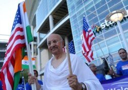 A man is dressed up as Mahatma Ghandi while people celebrate before a "Howdy, Modi" rally celebrating India's Prime Minister Narenda Modi at NRG Stadium in Houston, Texas, Sept. 22, 2019.