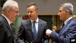 Hungarian Foreign Minister Peter Szijjarto, center, speaks with Malta's Foreign Minister Carmelo Abela, right, and European Commissioner for International Cooperation Neven Mimica during a meeting of EU foreign ministers at the Europa building in Brussels, Belgium, May 28, 2018. EU foreign ministers were seeking to protect the bloc's strategic and economic interests in Iran.