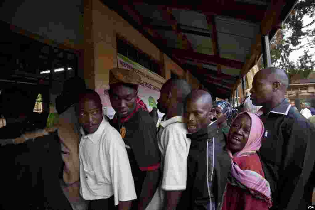 After waiting in line for more than six hours, voters complained about delays in opening the polls to an IEBC official at the Kibera Primary School, March 4, 2013. (R. Gogineni/VOA)