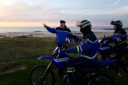 FILE - French gendarmes patrol the beach in Ambleteuse near Calais, northern France, Jan. 18, 2019, looking to halt migrants' bid to cross the English Channel.