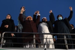 Opposition leaders, from right, Bilawal Bhutto Zardari, Owais Noorani, Maulana Fazlur Rehman and Maryam Nawaz of Pakistan Democratic Movement joint hands as they attend a rally in Lahore on Dec. 13, 2020.
