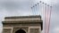 France's national colors trail above the Arc de Triomphe during the traditional Bastille Day parade on the Champs Elysees in Paris, July 14, 2014.