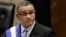 FILE - El Salvador's President Mauricio Funes stands in the National Assembly before speaking to commemorate the anniversary of his third year in office in San Salvador, El Salvador, June 1, 2012. Prosecutors in El Salvador say arrest warrants have been issued Friday for former President Funes and 30 others from his inner circle on a host of corruption charges.