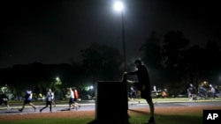 A man stretches as people exercise at a park in Buenos Aires, Argentina, June 8, 2020. 