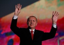 Turkey's President Recep Tayyip Erdogan waves to supporters following a rally to honor the victims of the July 15, 2016 failed coup attempt on July 15, 2019.