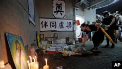 Mourners place flower tributes to a woman who supported the rally against the extradition law who jumped to her death a day earlier in Hong Kong, June 30, 2019. 