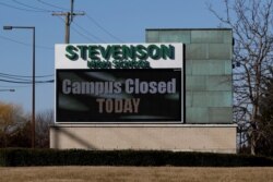 A sign outside a high school in Illinois says the campus is closed, March 13, 2020.