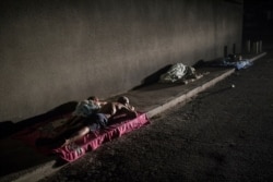 FILE - People sleep outside their homes during a blackout in the sweltering city of Maracaibo, Venezuela, May 15, 2019.