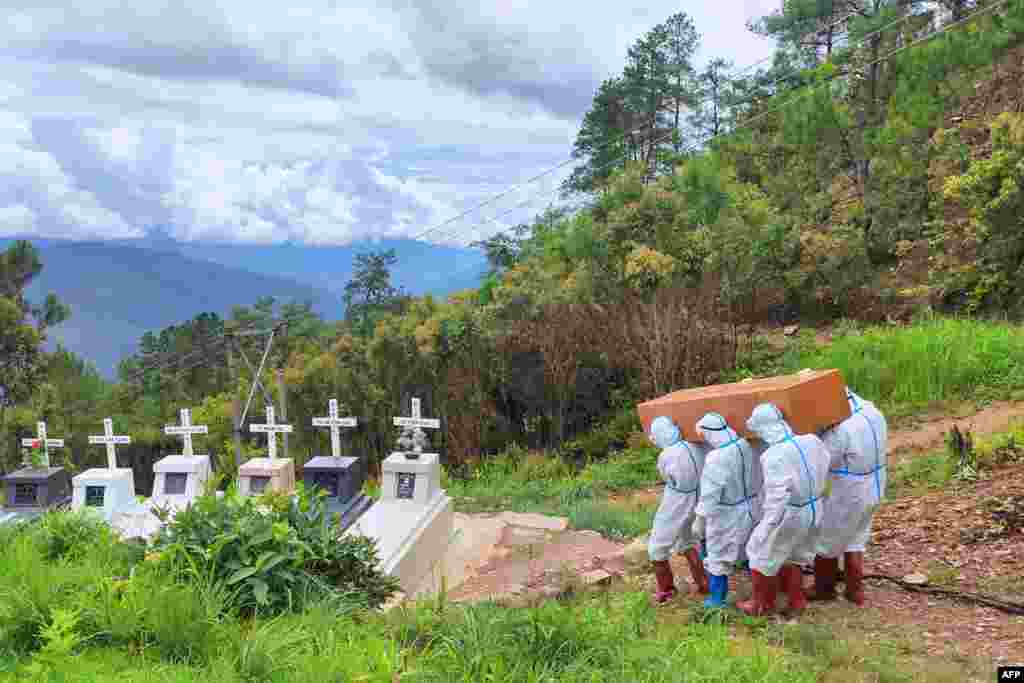 Health workers in protective suit carry a coffin with the body of a COVID-19 victim during a burial at a cemetery in Falam township in western Myanmar&#39;s Chin state. (Credit: Chinland Herald Daily News)