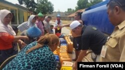 Warga di sebuah desa di Cibarusah, Bekasi di Jawa Barat sedang mengantri untuk mendapatkan air bersih. Kekeringan telah mengurangi pasokan air bersih untuk warga di wilayah tersebut. (Courtesy Photo/Firman Forsil)