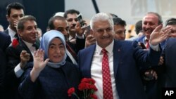 Binali Yildirim, Turkey's current Transportation Minister and founding member of the AKP, Turkey’s governing party, and his wife Semiha Yildirim salute supporters during party congress in Ankara, May 22, 2016. 