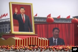 FILE - Participants cheer beneath   a ample  representation    of Chinese President Xi Jinping during a parade to commemorate the 70th day  of the founding of Communist China successful  Beijing, Oct. 1, 2019.