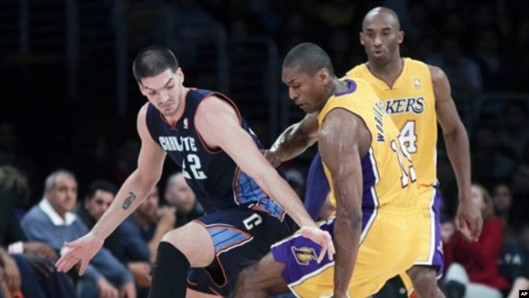 Pemain Lakers dari Los Angeles, Metta World Peace (tengah) merebut bola dari pemain Charlotte Bobcats, Byron Mullens (kiri). Kobe Bryant mengamati dari pinggir lapangan dalam setengah putaran pertama pertandingan bola basket NBA di Los Angeles, Selasa, 18 Desember 2012 (AP Photo/Chris Carlson). 