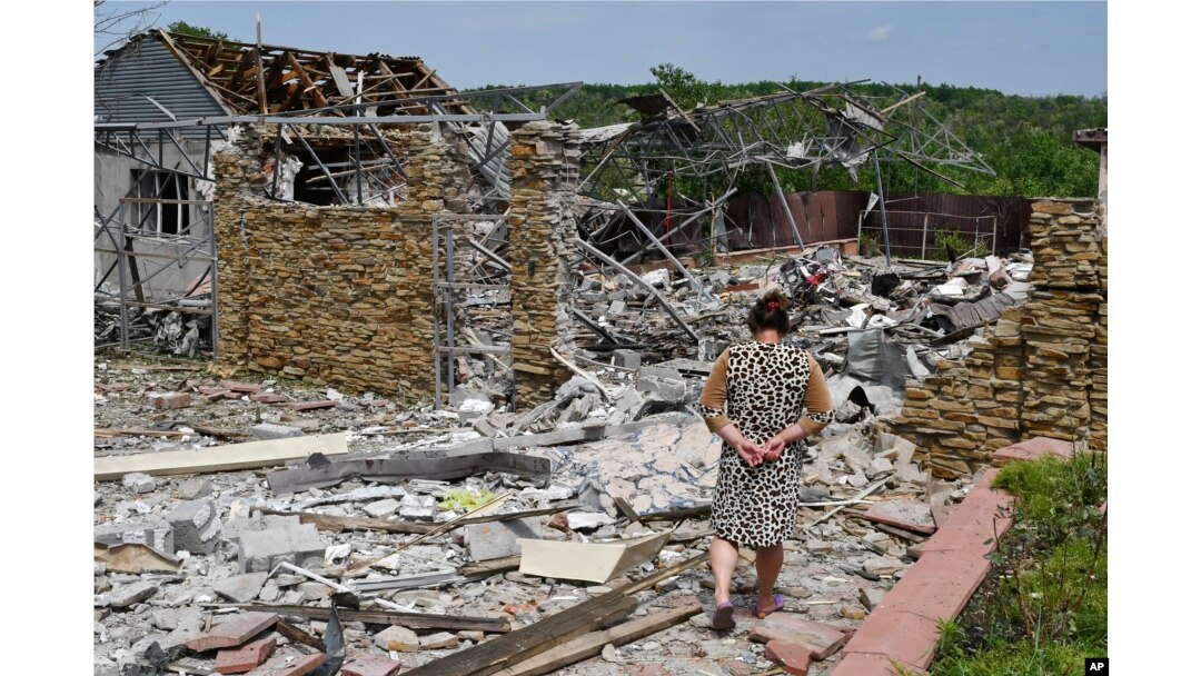 Seorang nenek berjalan di samping sebuah bangunan yang rusak akibat serangan rudal semalam di Sloviansk, Ukraina, Rabu, 1 Juni 2022. (Foto: AP)