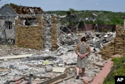 Seorang nenek berjalan di samping sebuah bangunan yang rusak akibat serangan rudal semalam di Sloviansk, Ukraina, Rabu, 1 Juni 2022. (Foto: AP)