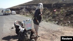 A Shi'ite militant mans a checkpoint on a road in Yemen's northwestern province of Omran, June 3, 2014. 