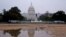 FILE - The U.S. Capitol building reflected in water at sunrise in Washington.