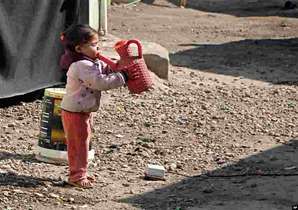 آب خوردن دختربچه از آفتابه در کمپ آوارگان در عراق