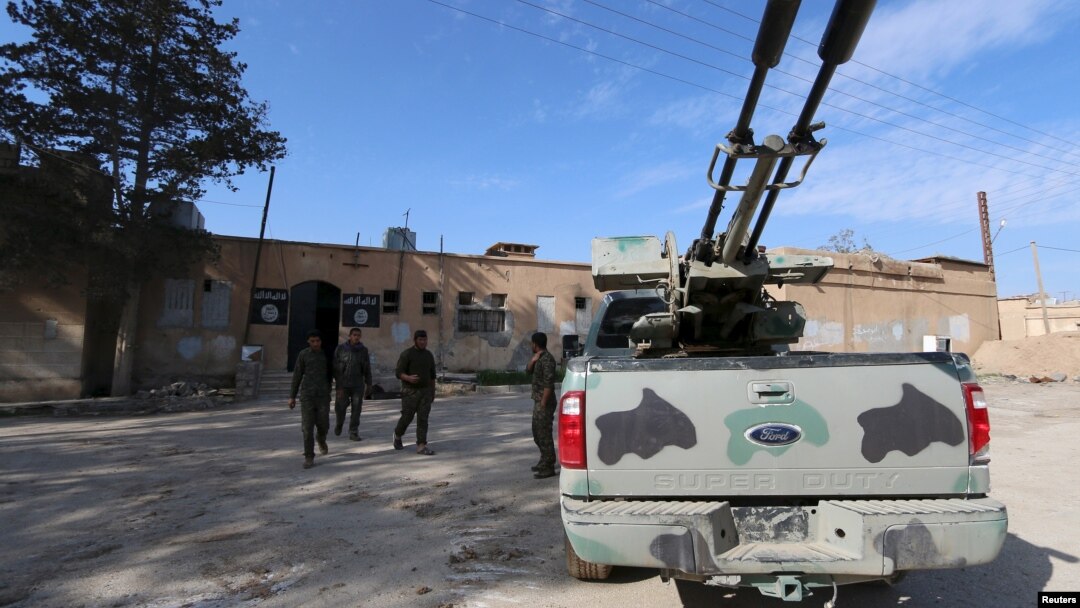 Các chiến binh Lực lượng Dân chủ Syria đi bên ngoài một nhà tù mà theo họ, thuộc về các chiến binh Nhà nước Hồi giáo, ở thị trấn al-Shadadi, tỉnh Hasaka, Syria, ngày 26/2/2016.