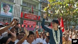 មេដឹកនាំ​ចលនា​ប្រជាធិបតេយ្យ​ភូមា គឺ​អ្នក​ស្រី Aung San Suu Kyi បក់ដៃ​ស្វាគមន៍​អ្នក​គាំទ្រ​​ក្នុង​អំឡុង​ពីធី​សម្ពោធ​ការិយាល័យ​​គណបក្សសម្ព័ន្ធជាតិ​ដើម្បី​លទ្ធិ​ប្រជាធិបតេយ្យ (National League for Democracy party) ប្រចាំ​​សង្កាត់ Mingalar Taung Nyunt របស់​ក្រ