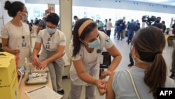 Un agent de la santé est inoculée avec un vaccin anti-COVID à l'hôpital des cliniques de Sao Paulo, au Brésil, le 18 janvier 2021.