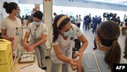 A health worker is inoculated with a COVID vaccine at the Clinicas Hospital in Sao Paulo, Brazil, Jan. 18, 2021.