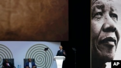 U.S. President Barack Obama, at podium delivers his speech at the 16th Annual Nelson Mandela Lecture at the Wanderers Stadium in Johannesburg, South Africa, July 17, 2018.