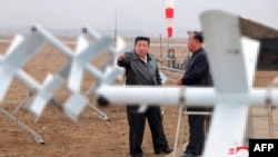 This picture taken on Nov. 14, 2024, and released from North Korea's official Korean Central News Agency via KNS on Nov. 15, 2024 shows North Korean leader Kim Jong Un, left, inspecting the performance test of drones at an undisclosed location. 