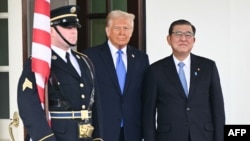 U.S. President Donald Trump greets Japanese Prime Minister Shigeru Ishiba upon arrival outside the White House in Washington on Feb. 7, 2025. 