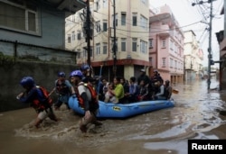 Tim SAR menggunakan rakit karet untuk menyelamatkan warga dari daerah banjir di dekat tepi Sungai Bagmati yang meluap setelah hujan lebat, di Kathmandu, Nepal, 28 September 2024. (Foto: Navesh Chitrakar/REUTERS)