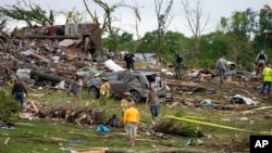 Trabajadores buscan entre los restos de las casas dañadas por el tornado, el martes 21 de mayo de 2024, en Greenfield, Iowa.