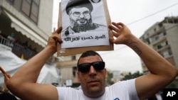 Pristalica Hezbolaha nosi sliku lidera pokreta Sajeda Hasana Nasralaha, tokom protesta u Bejrutu, 10. jula 2020. (Foto: AP)