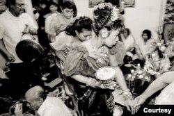 At an apartment in a public housing building on Chicago's north side, it's joy and trepidation at a traditional Cambodian wedding ceremony in the early 1990s. (Stuart Isett)